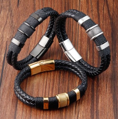 Una colección de tres pulseras de cuero negro para hombres con diferentes diseños de cierres de acero inoxidable.