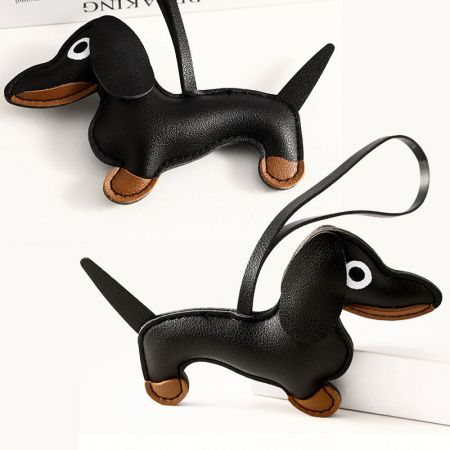 Vista en primer plano del charm de bolso de cuero negro en 3D de dachshund, destacando su detallada costura.