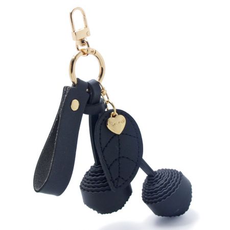 Le porte-clés cerise en PU cuir noir avec des coutures détaillées et des accessoires en or.