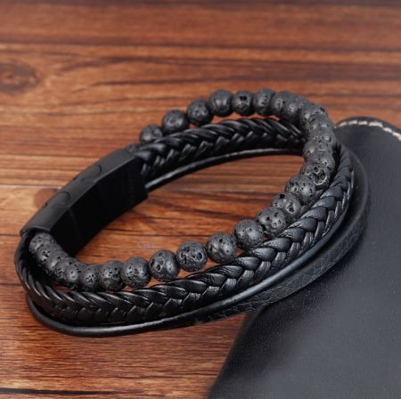 Närbild av herrarnas läder- och lavastenarmband.