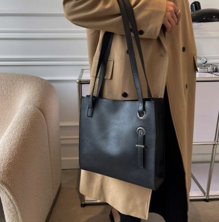 スタイルのコンテキストとして示された大容量トートバッグの黒いレザー版。