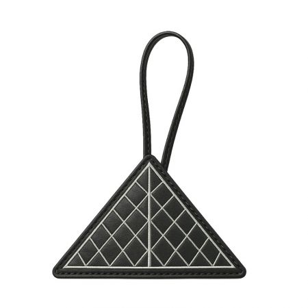 A modern, geometric leather charm with a triangular shape.