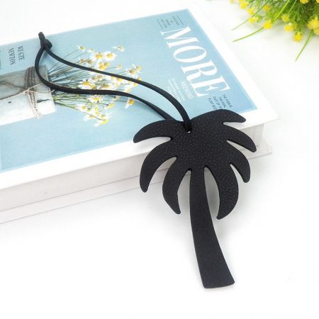 Gros plan sur le porte-clés en cuir de cocotier noir, montrant sa forme et sa texture détaillées.