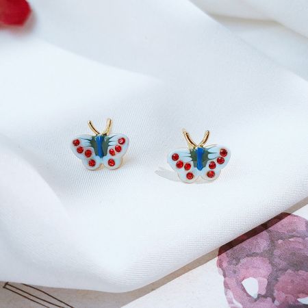 青と赤のエナメルの蝶のイヤリングのクローズアップ。