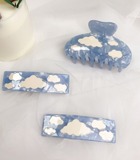 Close-up view of the blue acetate hair clip showcasing the detailed cloud design and glossy finish.
