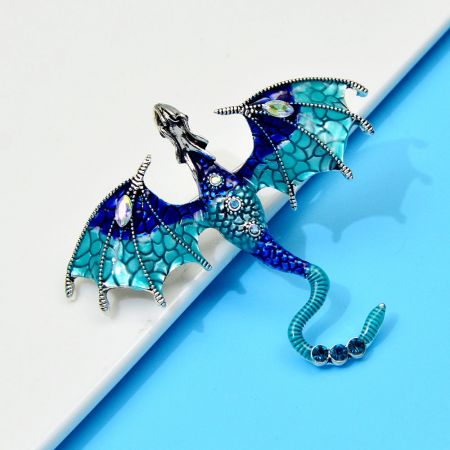 Blaue Variante der Emaille-Drache Brosche mit detaillierter Edelsteinarbeit.