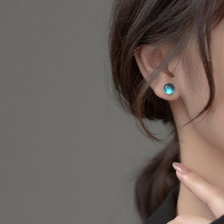 Model wearing the delicate blue crystal ball stud earring, showcasing its size and sparkle.