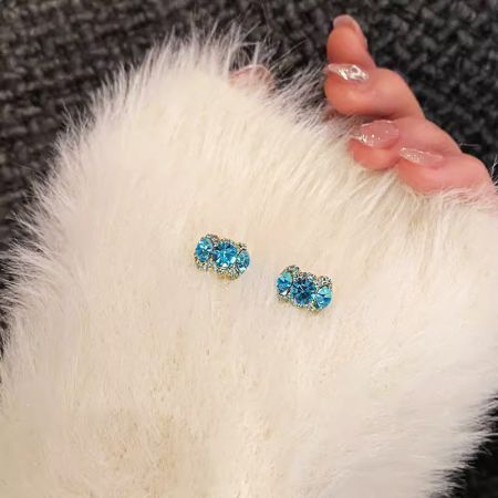 14kゴールドメッキの青いラインストーンスタッドイヤリングの上からのビュー。