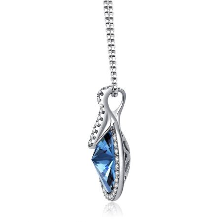 Schuin shot van de zilveren hanger met een grote blauwe edelsteen, waarbij de ingewikkelde zetting wordt benadrukt.