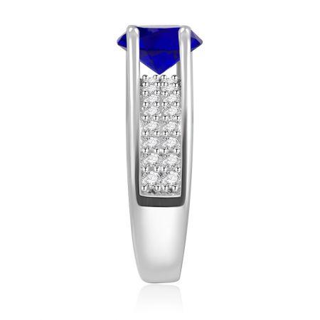 Schuin zicht op de rhodium-geplateerde messing ring, die de schittering van de centrale blauwe steen en zijaccenten toont.