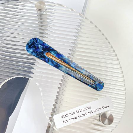 Een stijlvolle blauwe en gouden gemarmerde acetaathaarclip.