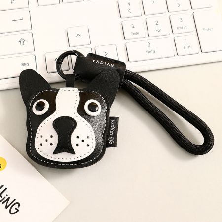 Gros plan sur le porte-clés en cuir noir de Boston Terrier avec une sangle de marque.