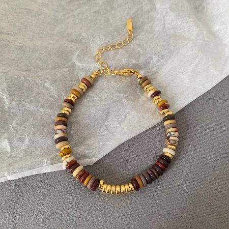 Vista detallada de una pulsera bohemia con cuentas marrones, beige y doradas, mostrando sus tonos terrenales.