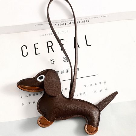 Toma detallada del charm de dachshund de cuero PU marrón, mostrando su forma y textura 3D de peluche.
