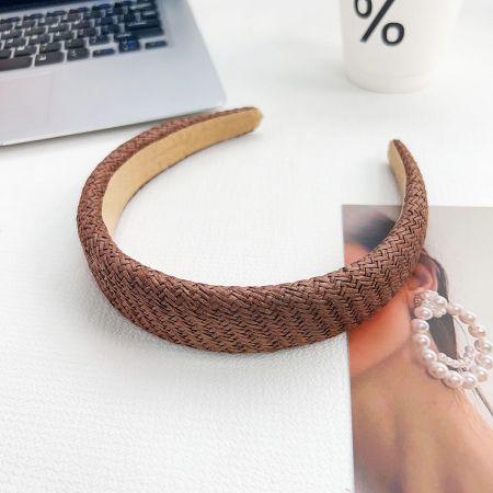 Close-up product shot of the brown woven braided headband.