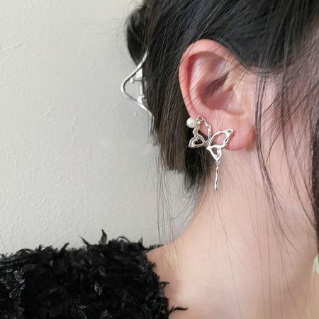 Un orecchino a forma di farfalla in argento sterling mostrato sull'orecchio di un modello, evidenziando il suo design ispirato al punk.