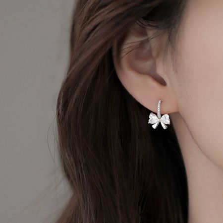 모델이 섬세한 스털링 실버 리본 스터드 귀걸이를 착용하고 있으며, 그 우아한 모습을 보여줍니다.