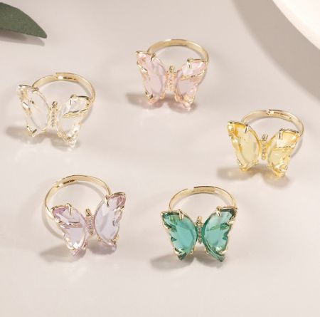 Collection of adjustable butterfly rings available in various gemstone colors.