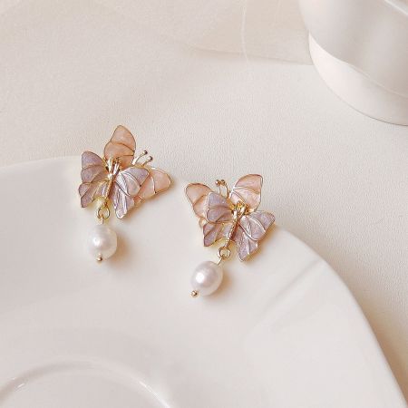 Boucles d'oreilles doubles en émail plaquées or 14k en gros avec des gouttes de perles d'eau douce (5 paires) - Une paire de boucles d'oreilles doubles en forme de papillon en émail plaquées or 14k avec de délicates gouttes de perles d'eau douce, présentées sur un fond blanc épuré.