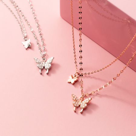 Conjunto de collares choker de mariposa de doble capa en plata de ley 925. - Una colección de collares choker de mariposa de doble capa en plata de ley 925, exhibidos en acabados de plata y oro rosa, destacando los delicados colgantes de mariposa.