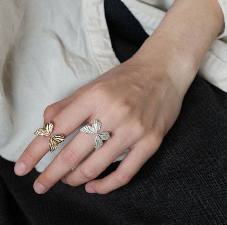 Twee sterling zilveren vlinder ringen met ingewikkelde vleugeldetails zij aan zij weergegeven