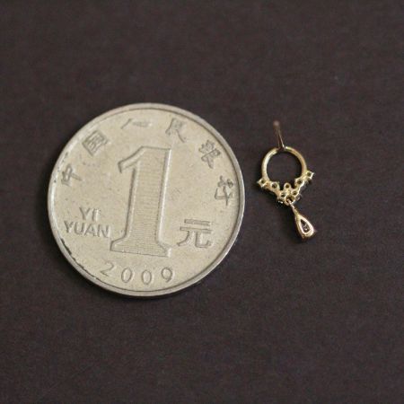 Size comparison of the 925 silver gold teardrop hoop earring next to a Chinese 1 yuan coin.