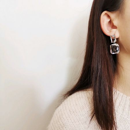 クリアクリスタルイヤリングのスタイリングショットで、その多様なルックを示しています。