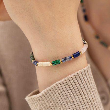 手首に着用されたカラフルなビーズのボヘミアンブレスレットのクローズアップで、その鮮やかなスタイルを紹介しています。