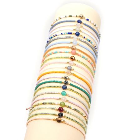 Un assortimento di braccialetti colorati intrecciati a mano esposti, che mostrano diverse combinazioni di perline e pietre.