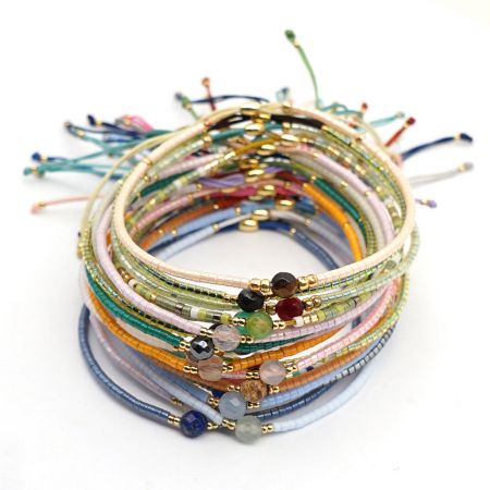 Una vivace pila di braccialetti bohemien in perline di vari colori e stili.