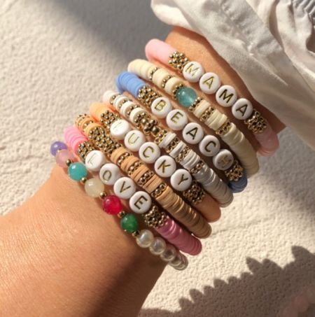 Una collezione di braccialetti in argilla polimerica colorata con messaggi personalizzati della collezione SS23.