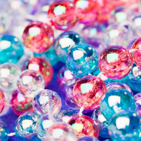 A macro shot showing the fine details and brilliant colors of the acrylic and alloy beads used in the necklace collection.