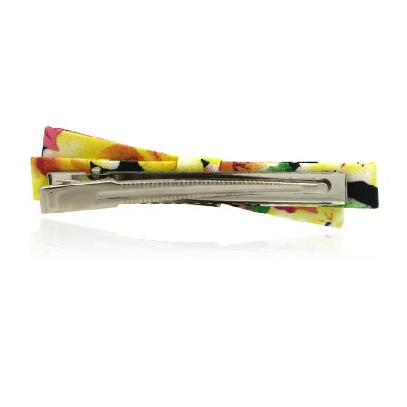 Zijaanzicht van de stoffen strik haarclip, met nadruk op de textuur.