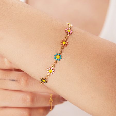 Close-up van de armband met levendige, multicolore emaille bloemen charms.