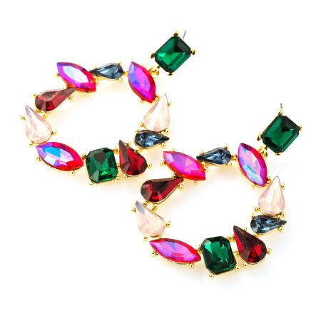 Profil latéral des boucles d'oreilles en pierres précieuses colorées, mettant en valeur le mélange de différentes formes de pierres et le sertissage en métal doré.