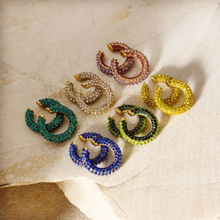 Een collectie van goudkleurige oorclip oorbellen met verschillende gekleurde rhinestones, waaronder blauw, groen en roze.