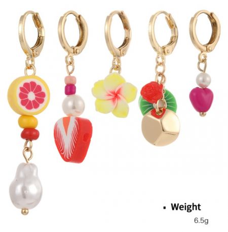 Een collectie van vijf kleurrijke gouden hoepel oorbellen met verschillende fruit- en bloemencharms gemaakt van zachte klei.