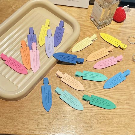 A vibrant arrangement of no-crease hair clips in various pastel colors on a wooden surface.