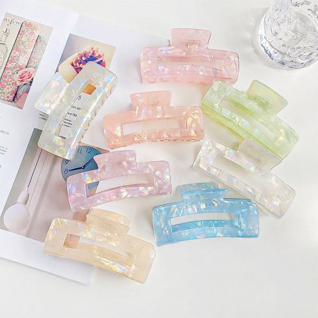 さまざまなスタイルと色合いのカラフルなアセテートヘアクリップのアレンジ。