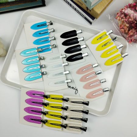 Collection of colorful creaseless hair clips on display cards in a white tray.