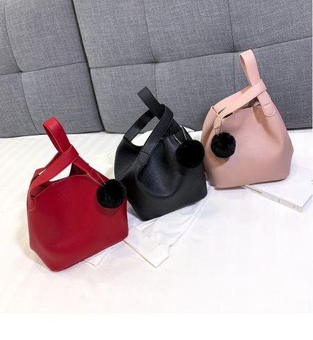 A collection of vibrant mini tote bags in different colors, each with a matching pom-pom charm.