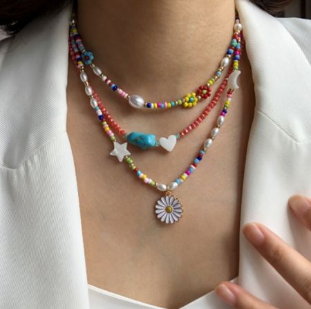 A set of layered necklaces with vibrant colorful beads and assorted charms.