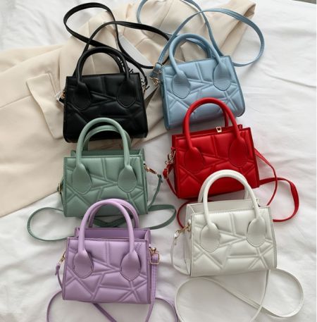 A vibrant collection of six small, quilted handbags in various colors, showcasing the available style options.