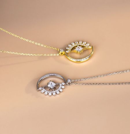 Detalle en primer plano del colgante de luna creciente y estrella, destacando el intrincado engaste de pavé de las piedras de circonita cúbica blanca.