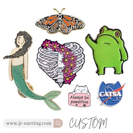 Detailed custom enamel pins including mermaid, butterfly, and frog designs, highlighting intricate craftsmanship.