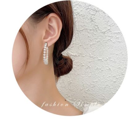 Una modelo lleva los pendientes de aro CZ redondos brillantes de 40 mm para mostrar cómo se ven al usarlos.