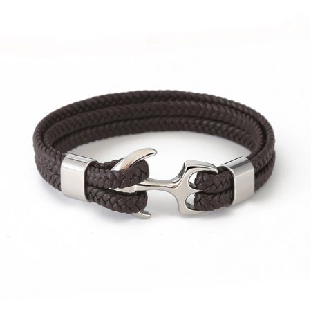 Brazalete de ancla para hombres de acero inoxidable con cuero genuino - Un brazalete de ancla para hombres de acero inoxidable que presenta una banda de cuero genuino trenzado de color marrón oscuro y un cierre de ancla de plata pulida.