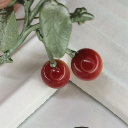 The cherry brooch shown from a different angle to display its three-dimensional quality.