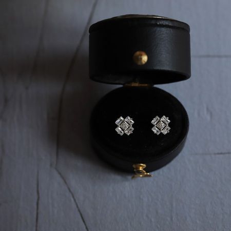 Gli orecchini a forma di cubo di ghiaccio in argento sterling presentati in una lussuosa scatola di gioielli in pelle nera.