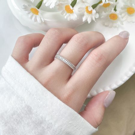 Anelli minimalisti in argento sterling 925 con CZ a perline all'ingrosso - Set di 5 - Un anello minimalista in argento sterling 925 con accenti in CZ a perline di un set all'ingrosso di cinque, mostrato indossato su un dito per evidenziare il suo design elegante per l'uso quotidiano.